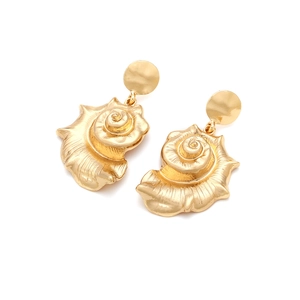 Macro shot of long golden conch shell alloy earrings with realistic spiral textures