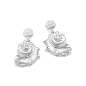 Detail view of silver conch shell drop earrings with hammered metal stud texture