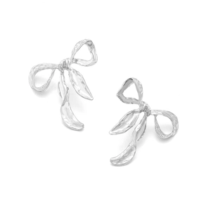 Detail of silver bow earrings featuring a unique wrinkled metal texture and ribbon design