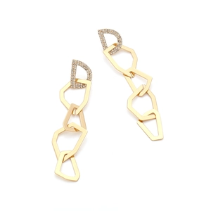Détail de boucles d'oreilles pendantes dorées avec clou en D scintillant et maillons