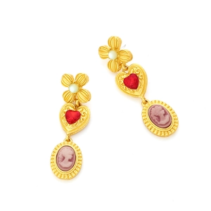 Detail of vintage palace style drop earrings with heart ruby and cameo portrait relief