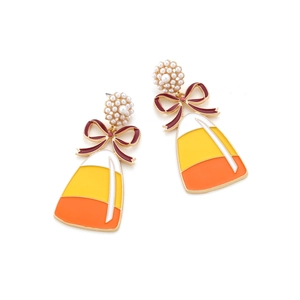 Close-up of candy corn earrings with enamel bow and imitation pearl cluster details