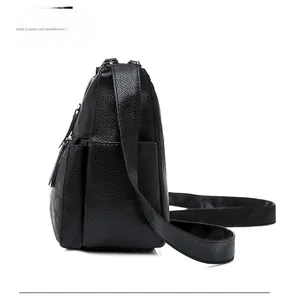 Detailed side view of black pebble grain leather shoulder bag with zipper pocket