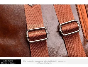 Detail view of adjustable fabric shoulder strap with silver metal buckle on brown leather bag