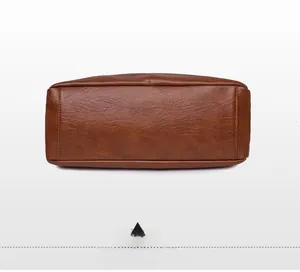 Detailed view of the bottom of a brown PU leather shoulder bag showing stitching and texture
