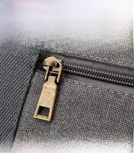 Dettaglio di cerniera in metallo bronzo su borsa a tracolla casual in tela capiente