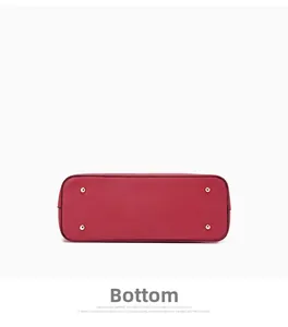 Detail view of red handbag base with four golden protective metal feet and fine stitching