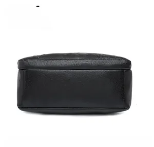 Detailed view of the black pebbled leather handbag bottom with floral embossing