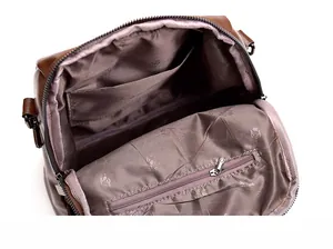 Detail of soft brown leather backpack interior with rose pattern lining and zipper pocket