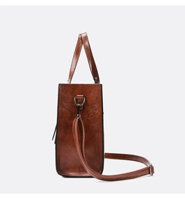 Vue latérale du sac à main en cuir marron montrant l'anneau D et les détails de texture