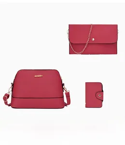 Three-piece set of burgundy leather bags including handbag, chain clutch, and wallet