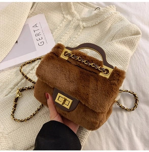 Détail d'un sac à main en peluche marron avec fermoir doré et bandoulière chaîne