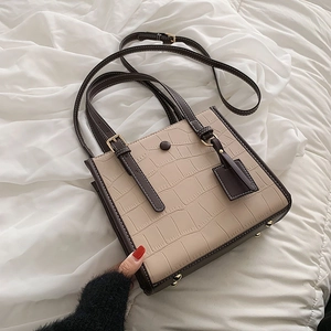 Beige and brown crocodile embossed tote bag with adjustable strap on white fabric