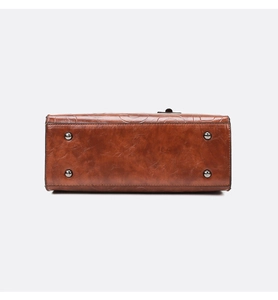 Vue détaillée du fond de sac en cuir vintage caramel avec rivets de protection en métal