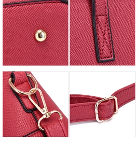 Detail of red Saffiano leather bag with gold rivets, stitching, and metal hardware