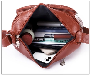 Détail de l'intérieur compartimenté du sac à bandoulière en cuir PU marron roux