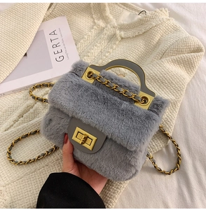 Détail d'un sac à main gris en fausse fourrure avec chaîne dorée et fermoir métallique