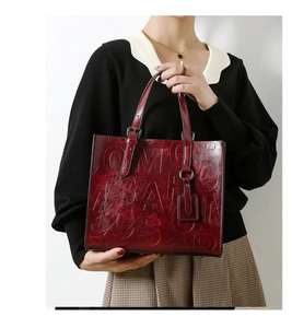 Vue détaillée de la texture en cuir gaufré bordeaux brillant sur le sac cabas