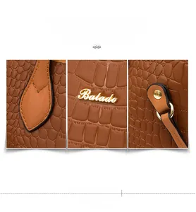 Close-up of golden Balado logo and metallic D-ring on brown crocodile pattern leather bag