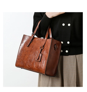 Vue détaillée du sac à main rétro en cuir marron avec lettres embossées et boucles métal