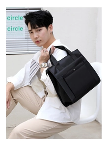 Business casual black nylon laptop bag with multiple compartments shown on a male model