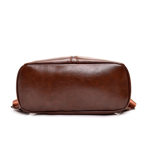 Bottom view of a vintage dark brown PU leather backpack with precise stitching detail
