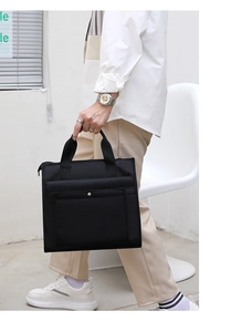 Business man carrying water-resistant black nylon laptop bag with multi-compartments
