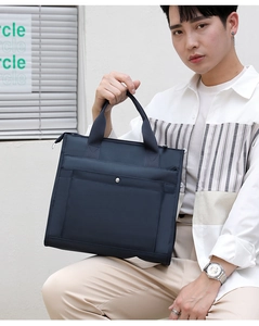 Detail of navy blue water-resistant nylon laptop bag with durable handles and snap pocket