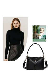 Detail of a minimalist black lychee grain leather tote with gold zipper and shoulder strap
