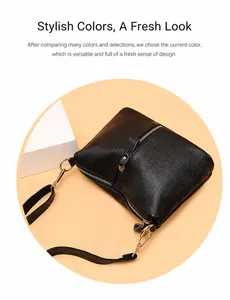 Detail of black pebbled leather crossbody bag featuring gold zippers and hardware