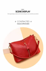Detail of red lychee grain leather handbag with vertical gold metal zipper accents