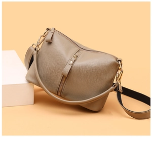 Detail of khaki leather bag with lychee texture and dual interchangeable shoulder straps
