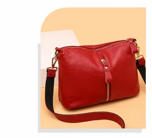 Close-up of red lychee pattern leather bag with gold hardware and two-tone shoulder strap