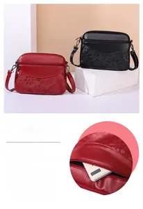 Detail showing red embossed leather shoulder bag with floral pattern and multiple zippers