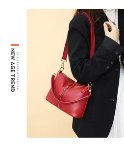 Close-up of red lychee grain leather handbag with gold hardware and front zipper detail