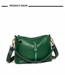 Detail of dark green leather shoulder bag with lychee texture and gold-tone zippers