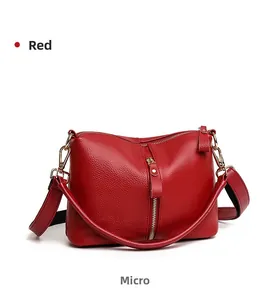 Detailed side view of red pebbled leather shoulder bag with vertical zipper and gold hardware