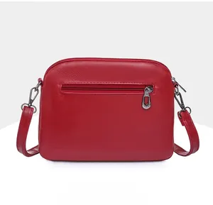 Detailed back view of red leather crossbody bag with silver zipper pocket and D-rings