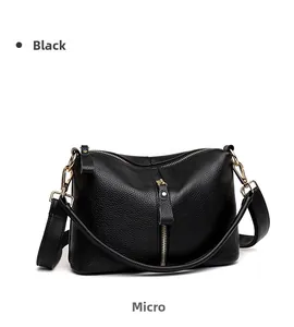 Detail view of premium black lychee-textured leather handbag with golden zippers