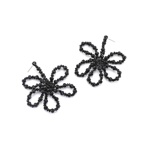 Detail of handmade bohemian earrings with black faceted beads in a six-petal flower design