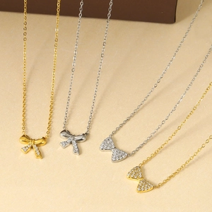 Vue détaillée des pendentifs nœud en titane avec zircons brillants en finitions or et argent