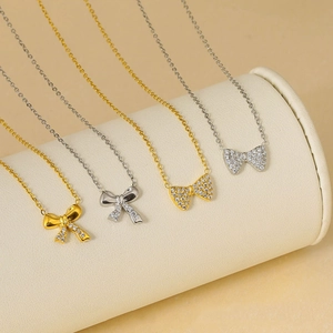 Colliers élégants en acier titane avec pendentif nœud et zircons en tons or et argent