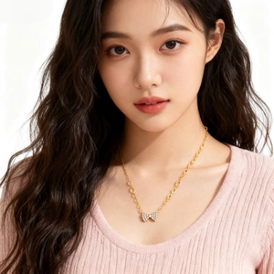 Gros plan d'un collier pendentif nœud doré avec zircons sur le décolleté du mannequin