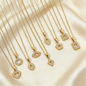 Macro detail of various gold-plated geometric pendants with sparkling cubic zirconia inlay