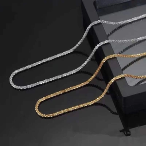 Detailed close-up of sparkling gold and silver cauliflower chain necklaces on black display