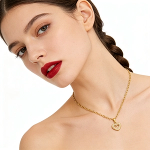 Detail of gold heart pendant with cubic zirconia inlay on a delicate chain for women