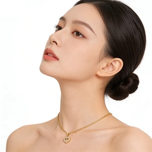 Close-up of a gold heart pendant necklace with zircon stones worn by a model