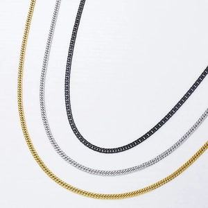 Gros plan de colliers à maillons cubains tricolores en or, argent et acier inoxydable noir