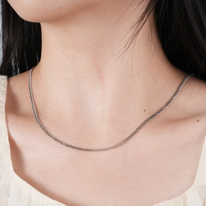 Gros plan d'un collier chaîne gourmette en acier inoxydable argenté sur un mannequin