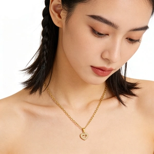 Elegant gold heart necklace with zircon pave setting shown on a female model's neck